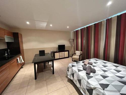 une chambre avec un lit et un bureau et une cuisine dans l'établissement Carnot, à Cannes