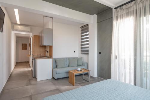 a bedroom with a blue bed and a kitchen at Vrahakia beach in Sarti