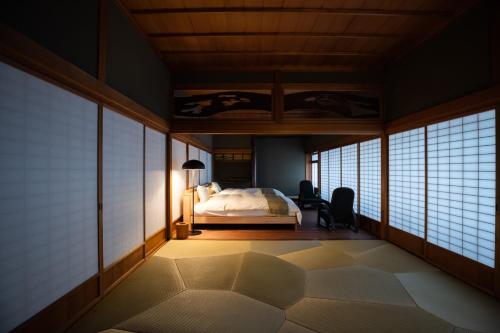 1 dormitorio con 1 cama en una habitación con ventanas en Kusakimomotose - Vacation STAY 15482 en Yuzawa
