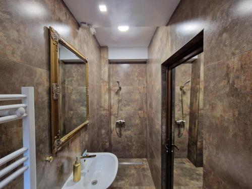 La salle de bains est pourvue d'un lavabo et d'une douche. dans l'établissement Pensiunea Escape, à Iaşi