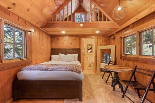 - une chambre avec un lit dans une cabane en bois dans l'établissement Houston Camp - North Shore Rental with Four Completely Remodeled Cabins plus a private hot tub!, à Carnelian Bay
