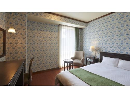 a bedroom with a bed and a desk and a chair at Old England Dogo Yamanote Hotel - Vacation STAY 75541v in Matsuyama