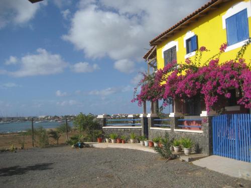 een geel huis met bloemen erop bij Casa Torre in Palmeira
