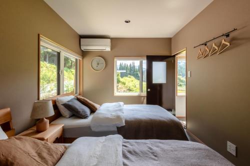 een slaapkamer met 2 bedden en een raam bij Okuaga Shichimeian Rakura - Vacation STAY 67125v 