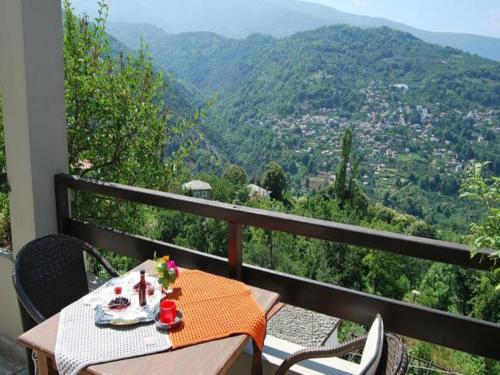 a table and chairs on a balcony with a view at Guesthouse Kallisti in Anilio Pelion