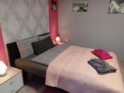 een slaapkamer met een bed en een rode muur bij Százszorszép Vendégház in Csongrád