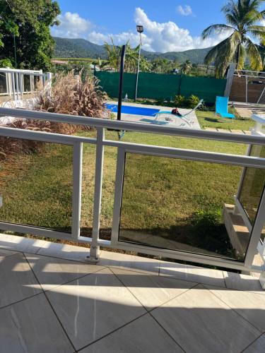 a metal railing on a balcony with a pool at Les papillons Doré in Sainte-Rose