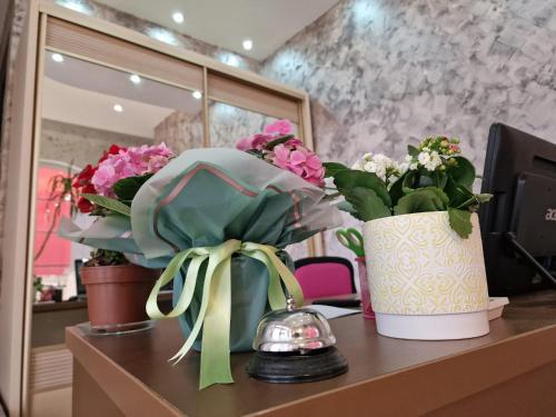 deux vases remplis de fleurs sur une table dans l'établissement Pensiunea Escape, à Iaşi