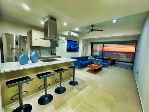 uma cozinha e sala de estar com um sofá azul em Altomare Seaview em Mazatlán