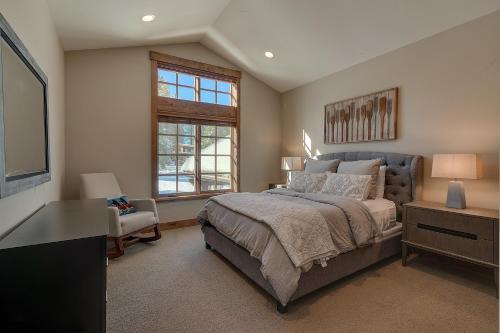 een slaapkamer met een bed, een bureau en een raam bij Mountain Majesty at Grays Crossing - Luxury 4BR 4BA w Private Hot Tub in Truckee