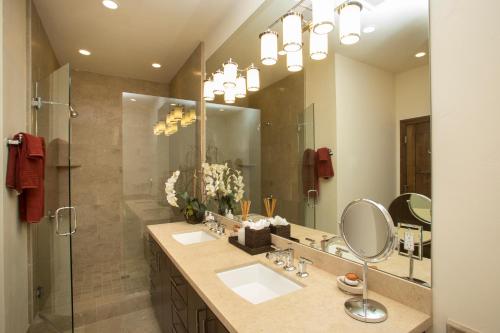 a bathroom with two sinks and a shower with a mirror at Mountainside - Luxury Northstar Ski-in Ski-Out - Swimming Pool and Gym! in Truckee