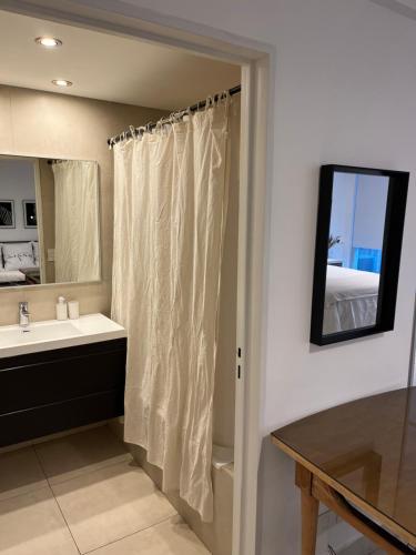 a bathroom with a shower curtain and a sink at Madero City Buenos Aires in Buenos Aires