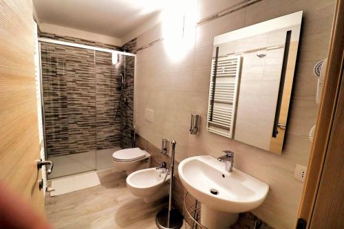 a bathroom with a sink and a toilet and a mirror at SENTIERI DEL GARDA in Arco