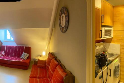 un soggiorno con divano e orologio sul muro di Location montagne le Revard a Pugny-Chatenod
