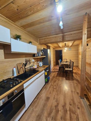 a kitchen and dining room in a log cabin at Zawoja Nad Koroną z jacuzzi in Zawoja