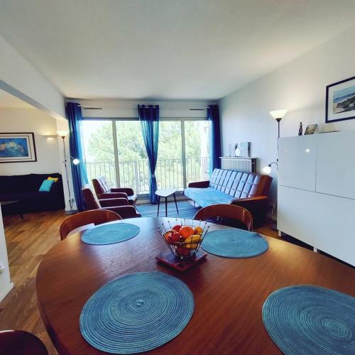 - un salon avec une table en bois et un bol de fruits dans l'établissement Spacious apartment near the sea, à Arcachon