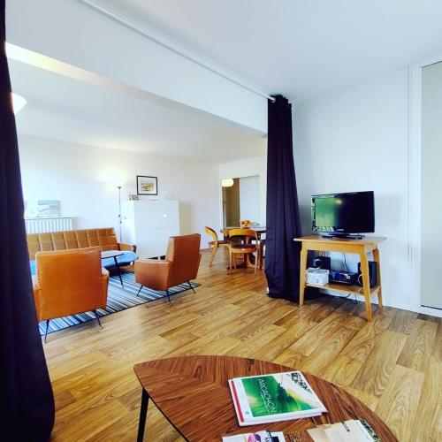un salon avec un canapé et une télévision dans l'établissement Spacious apartment near the sea, à Arcachon
