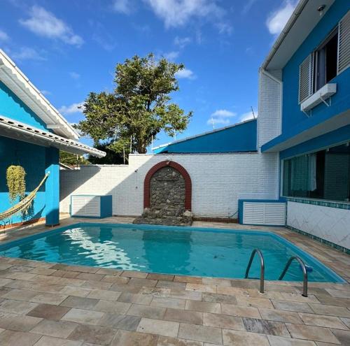 a swimming pool in front of a house at Hostel Litoral in Peruíbe