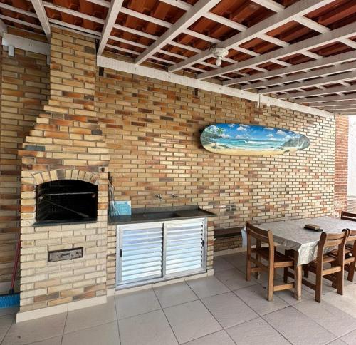 a patio with a brick oven and a table and chairs at Hostel Litoral in Peruíbe