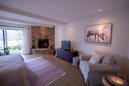 a living room with a bed and a couch and a fireplace at Amazing Lakemountain View 5min To Tremblant431 in Mont-Tremblant