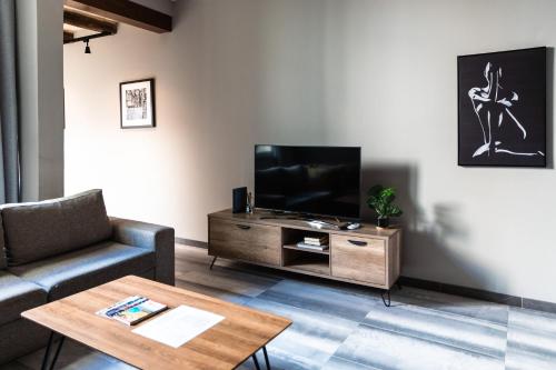 a living room with a tv and a couch and a table at Valletta Stylish 2 Beds Flat in Valletta