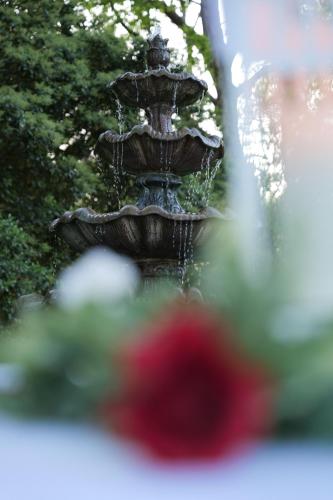 a fountain with a red flower in front of it at The Inn on Front Street in Statesville
