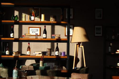 Alpine Lounge Kazbegi في كازباجي: غرفة مع رف مع زجاجات من النبيذ