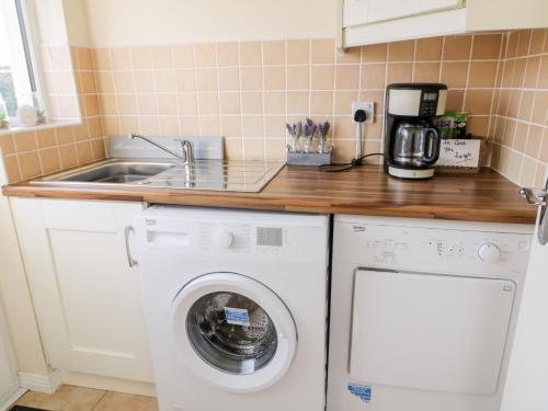 a kitchen with a washing machine and a sink at Coneyville in Derry Londonderry