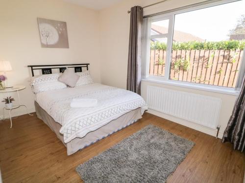 1 dormitorio con cama y ventana grande en Coneyville, en Derry Londonderry