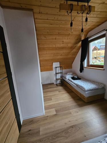 Pokój na poddaszu z łóżkiem i oknem w obiekcie Zawoja Domki z Jacuzzi w Zawoi