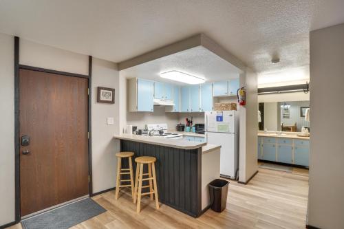 a kitchen with blue cabinets and stools in a room at Walkable Brian Head Condo Steps to Ski Resort! in Brian Head