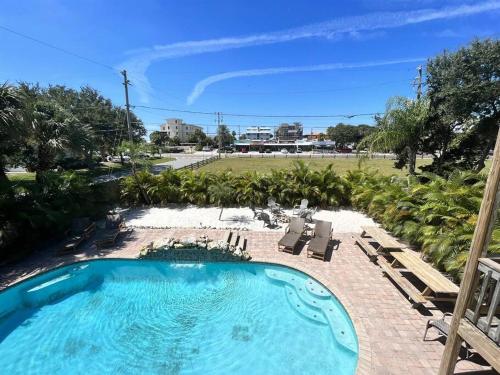 una piscina en un patio con sillas en 6 Bedrooms 4 Bath with sand and heated pool en Clearwater Beach