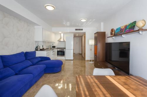 sala de estar con sofá azul y cocina en Piso familiar cerca del centro, AC y Wifi gratis (PA), en Valencia