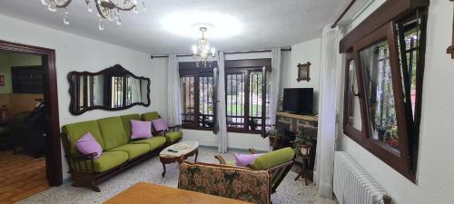 sala de estar con sofá verde y almohadas moradas en Villa Teresa con Aparcamiento y Wifi Incluido - Cangas De Onis, en Cangas de Onís