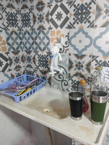 a sink in a bathroom with a tile wall at Casa praia cabuçu - azul com piscina in Saubara