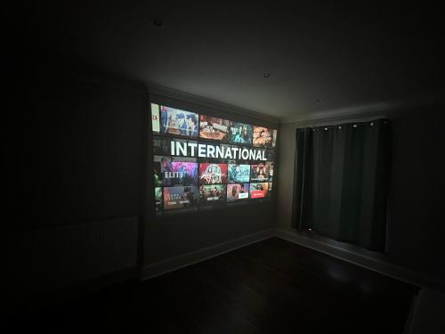 um quarto com televisão num quarto escuro em Liverpool Street Green Bedroom em Londres
