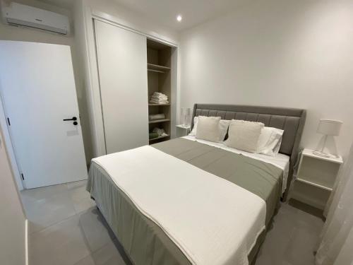 - une chambre dotée d'un grand lit avec des draps et des oreillers blancs dans l'établissement Casa Cova da Onça, à Olhão