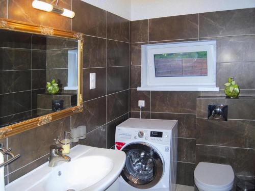 ein Badezimmer mit einer Waschmaschine und einem Waschbecken in der Unterkunft Terraced house with pool and sauna, Sieciemin in Sieciemin