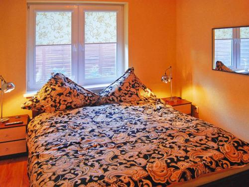 Bett in einem Zimmer mit 2 Fenstern in der Unterkunft Terraced house with pool and sauna, Sieciemin in Sieciemin