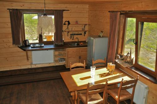 a dining room with a table and a kitchen at Kozichky Guest House in Tatariv