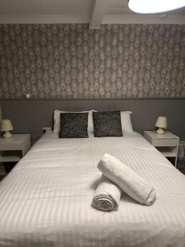 a bedroom with a large white bed with a blanket at The kings head in Chacewater