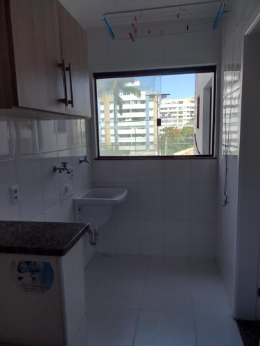 a bathroom with a window and a sink and a toilet at Apt Estrada do coco- Lauro de Freitas in Lauro de Freitas