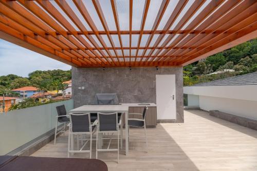 a wooden ceiling on a patio with a table and chairs at Ocean One Roatan in West Bay