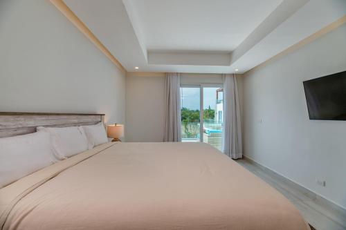 1 dormitorio con 1 cama grande y TV en Ocean One Roatan, en West Bay