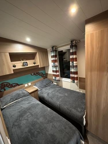 a small room with two beds and a window at Luxurious 6 Berth Swift Bordeaux on Lyons Robin Hood Rhyl in Meliden