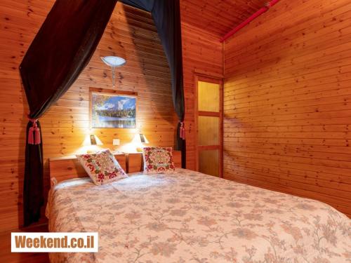 a bedroom with a bed in a wooden room at ערבה גארדן Arava Garden in H̱aẕeva