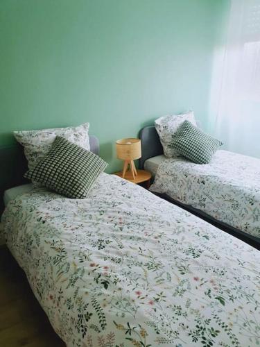 a bedroom with two beds with pillows on it at Le Lagon - 10 min aéroport et de Nantes in Rezé