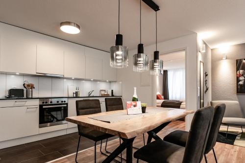 a kitchen and dining room with a wooden table and chairs at Spirit Apartments - Suite #2 - Zentral - Parkplatz in Brienz