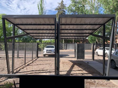 a metal structure with a car parked in a parking lot at Bosques de mayo Departamento 2 in Maipú