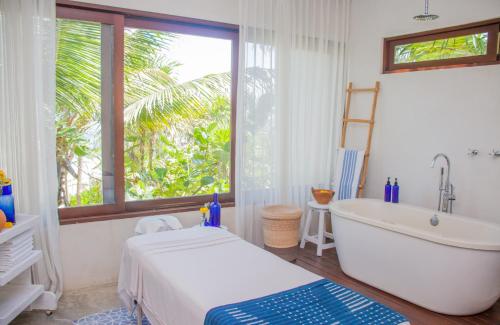 baño con bañera y ventana en Lula Seaside Boutique Hotel en Tulum